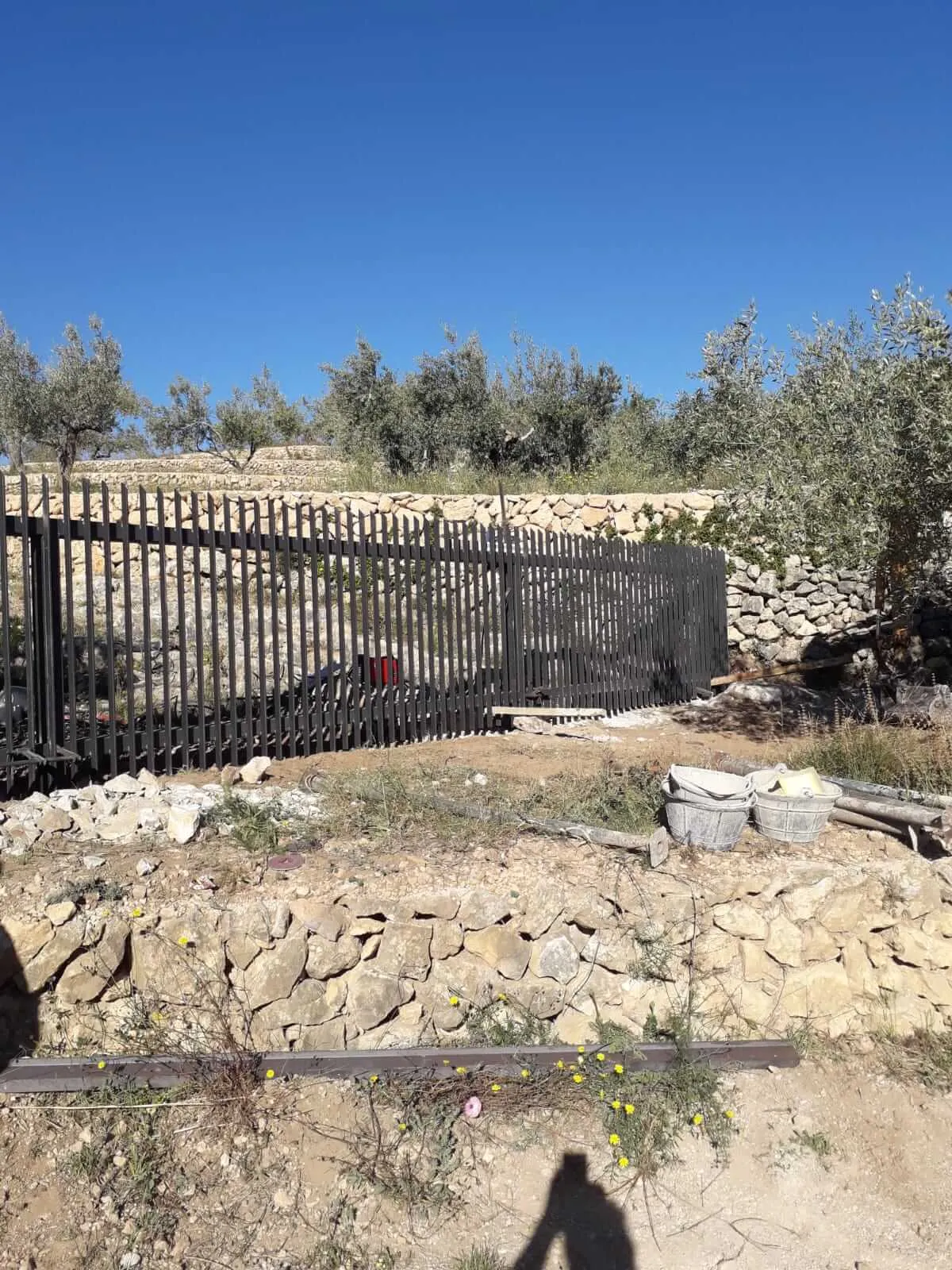 Construcción de puerta y cercado, para una casa de montaña, formada por acero pintado en forja