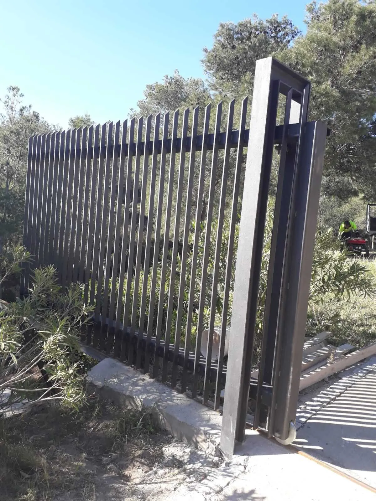 Construcción de puerta y cercado, para una casa de montaña, formada por acero pintado en forja